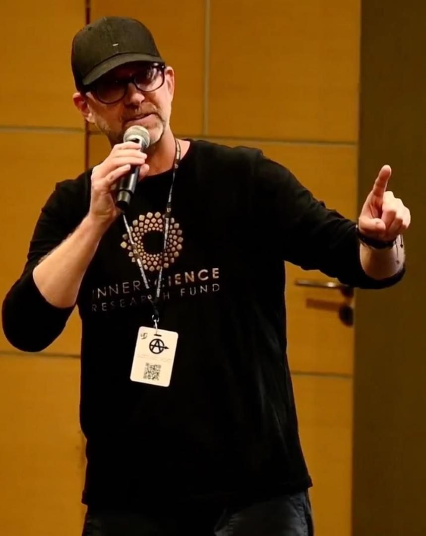 Aaron Grosskopf speaking, microphone in hand